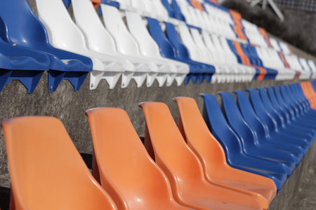 A bright line of orange plastic chairs lined the outdoor ground, bringing a vibrant energy to the...
