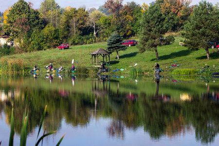 Fishermen enjoy a peaceful day by the lake.の写真素材