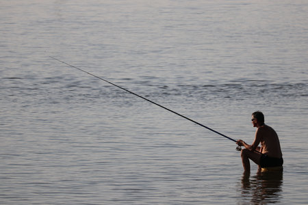 Man patiently fishing from the shore.の写真素材