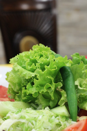 This close-up of a vibrant, fresh salad brimming with a variety of vegetables and lettuce leaves invokes feelings of nourishment, health, and abundanceの写真素材