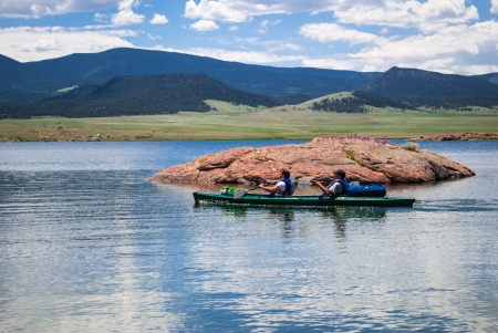 Kayakers on mountain lake with the Rocky Mountains in the background on a sunny dayのeditorial素材