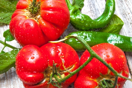 close up of organic heirloom tomatoes and peppers on a table in the sunの写真素材
