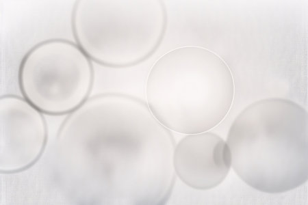 White glass circles on a white background. Abstract background for design. Backdrop.の素材