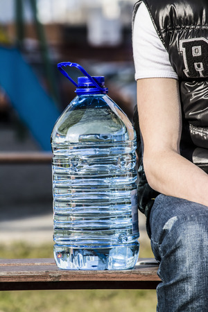 boy sitting with a bottle of waterの写真素材