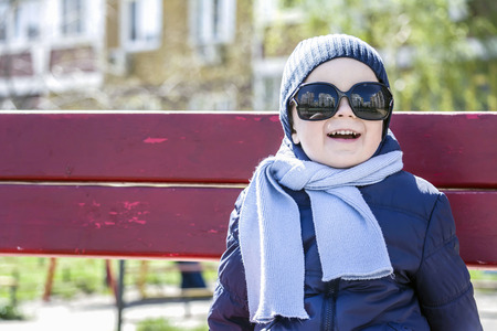 boy with glasses and scarf looks at the sunの写真素材