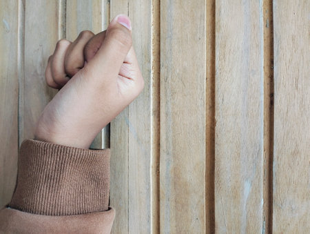 Hand knocking on a wooden door, Close up Knocking on the door, a woman's hand knocks on a wooden door.の写真素材