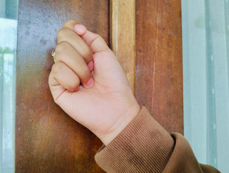 Hand knocking on a wooden door, Close up Knocking on the door, a woman's hand knocks on a wooden door.の写真素材