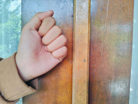Hand knocking on a wooden door, Close up Knocking on the door, a woman's hand knocks on a wooden door.の写真素材
