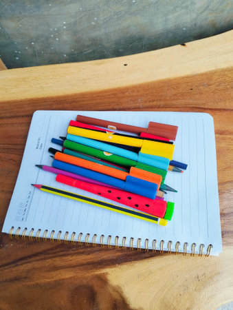 Stationery on wooden table with notebook, colorful markers, school suppliesの写真素材