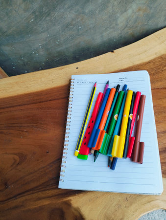 Stationery on wooden table with notebook, colorful markers, school suppliesの写真素材