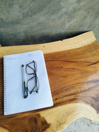 Open notepad with pen and glasses on wooden table. A Blank Sheet Of Notebook With The Items Of A Businessman. Ideal for branding and note-taking app presentations. Close upの写真素材