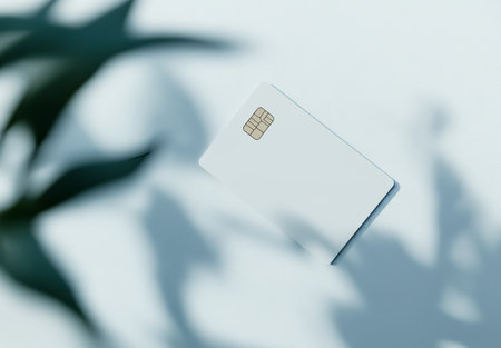 Elegant mockup of a white credit card with a plant shadow on a light blue backgroundの写真素材