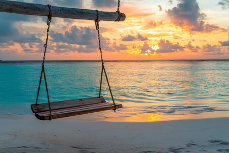 Serene wooden swing on maldives beach at sunset, embraced by turquoise waters and dreamy skiesの写真素材
