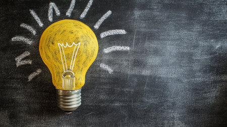 Creative yellow light bulb illustration on blackboard background for business and education themesの写真素材
