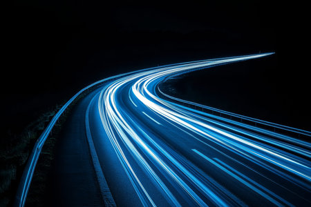 Long exposure night photography of light trails on road featuring blue and white colors