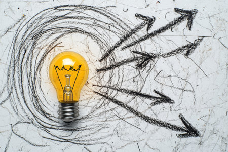 Yellow light bulb with scribbled arrows symbolizing innovative research ideas on white backgroundの写真素材
