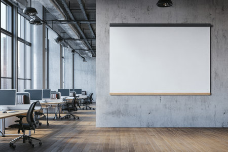 Empty white poster mockup in a modern open office with wooden floors and concrete wallsの写真素材