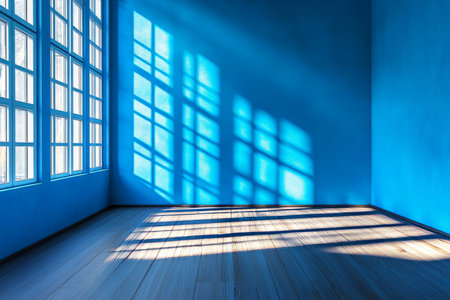 Bright daylight illuminates a blue room with wooden floor and shadowed walls in stunning detailの写真素材