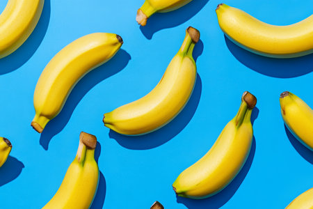 Flat lay photography of bananas on a blue background showing a vibrant pattern from aboveの写真素材