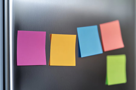 Vibrant sticky notes on a stainless steel refrigerator in a modern kitchen with text space
