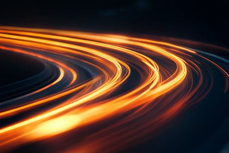 Curved road with abstract orange light trails and motion blur against a dark backgroundの写真素材
