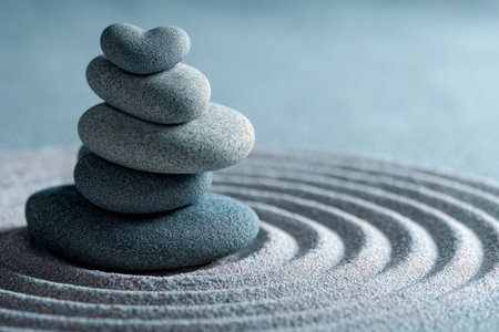Serene heart shaped stones surrounded by circular ripples in soft blue sand backgroundの写真素材