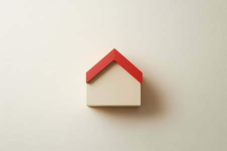3d minimalist house icon with red roof and beige walls on white background for real estate useの写真素材