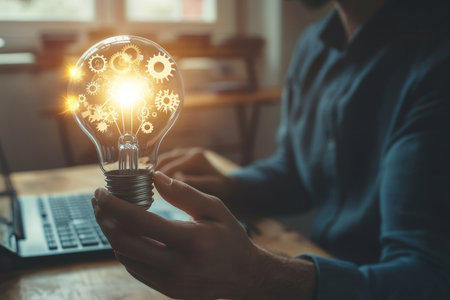 Glowing light bulb in the hands of a man in a business suit. The concept of a successful idea.の写真素材
