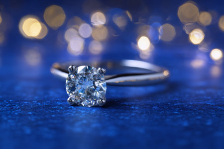 A stunning diamond ring set against a blue background with beautiful bokeh lighting effectsの写真素材