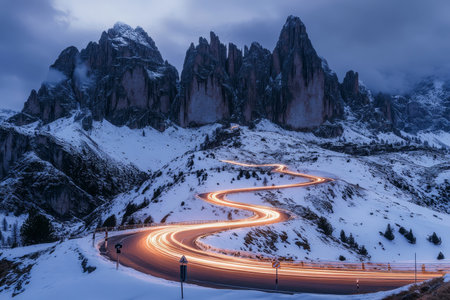 Long exposure of a winding mountain road in the Italian dolomites at dawn with light trailsの写真素材
