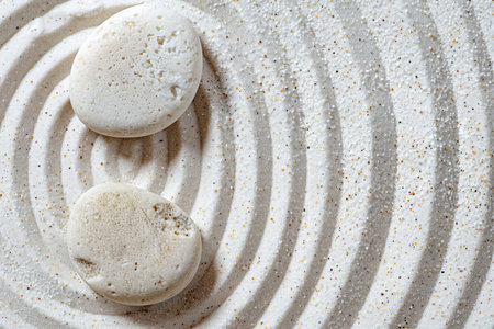 Tranquil zen rock garden with circular patterns in white sand, top view for serene reflection