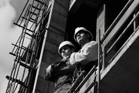 Two young architects collaborating at a building construction site for innovative design solutionsの写真素材