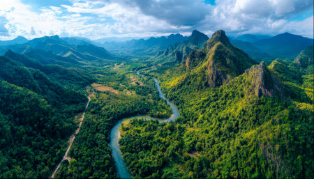 Towering verdant peaks surround a serpentine waterway, creating a vibrant, untouched tropical scene full of natural curves and lush foliage.の写真素材