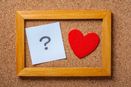 A heartfelt note awaits discovery beside a vibrant red heart pinned on a rustic corkboard, framed by...