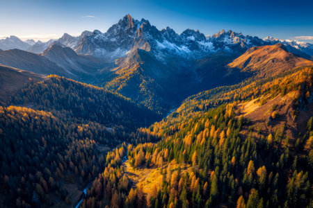 Panoramic landscape capturing vibrant autumn foliage amid towering peaks and dense greenery, evoking serenity and inspiring outdoor adventure scenes.の写真素材