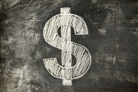 A vivid chalk sketch of a dollar symbol stands prominently against a dark blackboard, symbolizing...