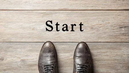 Elegant brown leather footwear aligned on a polished wooden surface, with a motivational start sign...