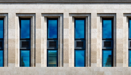 A sleek contemporary structure featuring expansive vertical windows bordered by rugged stone accents, evoking elegance and timeless sophistication.の写真素材