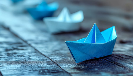 Brightly colored paper vessels rest on aged wooden planks, evoking nostalgia and adventure, perfect for themes of childhood joys and creative decor.の写真素材
