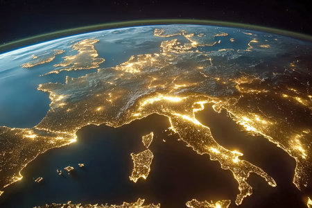 A breathtaking nightscape from orbit highlighting Europe's glowing urban hubs and shining coastlines against the dark surrounding waters.の写真素材
