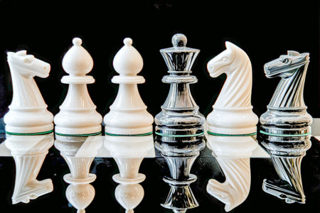 A sophisticated arrangement features a clear glass set and pristine white chess figures, reflecting...