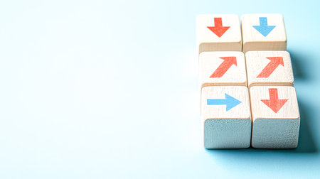 Colorful wooden tokens featuring bold red and blue arrows point in various directions, set against a soft blue backdrop for engaging visual communicatの写真素材