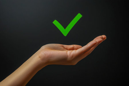 A hand firmly grasping a vibrant green checkmark, symbolizing achievement, validation, and positive...