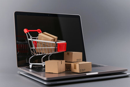 Online shopping concept with laptop and full cart for e-commerce and internet retailingの写真素材