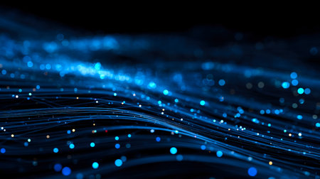Dynamic blue light trails with shimmering particles cascade through a dark space, evoking futuristic connections and high-tech energy flow.の写真素材