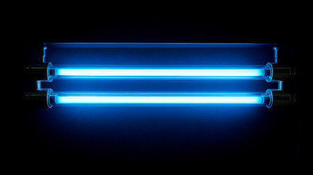 Vibrant azure ultraviolet tubes cast an intense luminous beam, creating a striking contrast and a futuristic ambiance against the shadowed backdrop.の写真素材