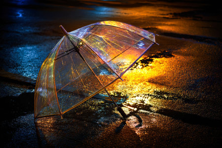 A shimmering umbrella mirrors vibrant urban hues, casting a glow on slick pavement as night falls,...