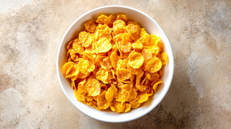 A crispy, amber-hued cereal fills a simple bowl, casting a warm glow against a plain, muted...
