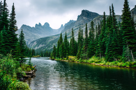 A tranquil alpine waterscape reflecting dense forested slopes and majestic summits, evoking peace and natural grandeur in a pristine mountain setting.の写真素材