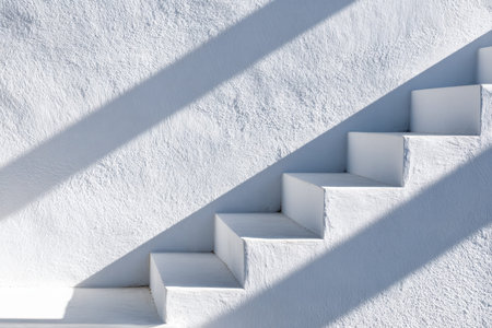 A sleek white staircase set against a textured wall creates dynamic shadows, emphasizing clean lines...
